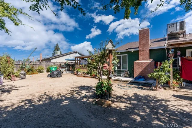 a view of a backyard with large trees and a small barn