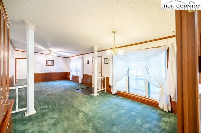 a view of a large room with wooden floor and windows
