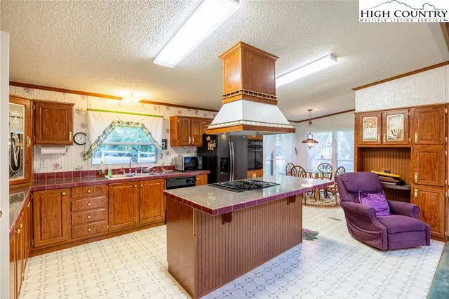a kitchen with stainless steel appliances granite countertop a refrigerator and a stove top oven