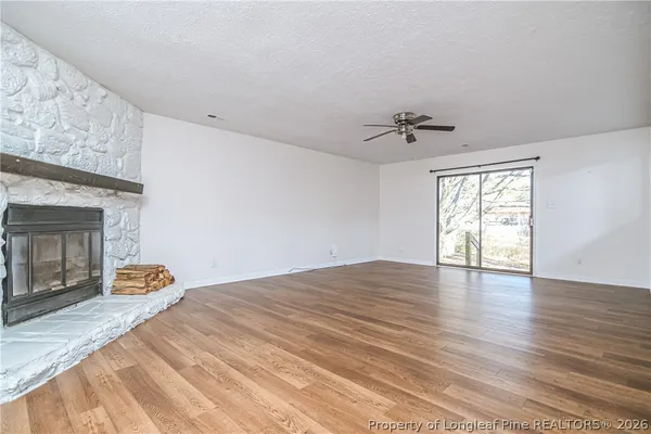 a view of an empty room with a window and a fireplace