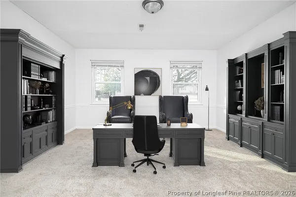 a view of a workspace with furniture and a window