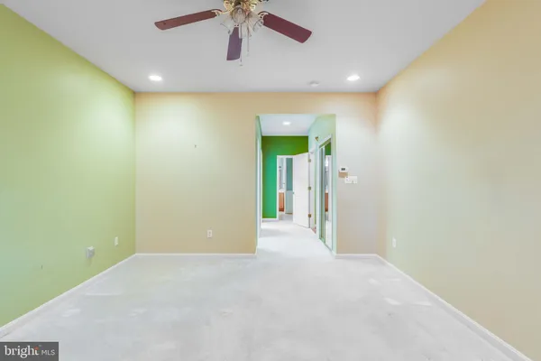 an empty room with a ceiling fan and window