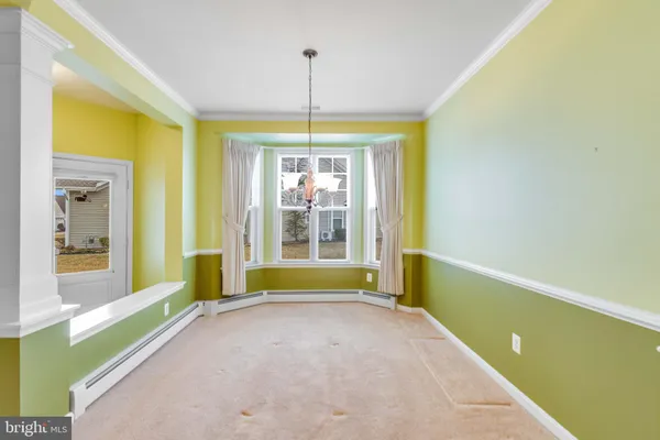 a view of an empty room with a fireplace and a chandelier