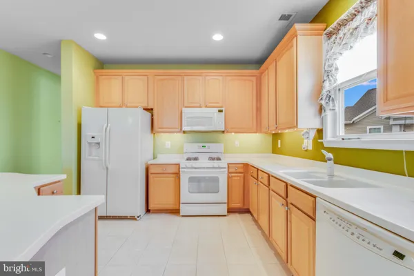 a view of kitchen with kitchen island stainless steel appliances a stove a refrigerator a sink and a dining table view