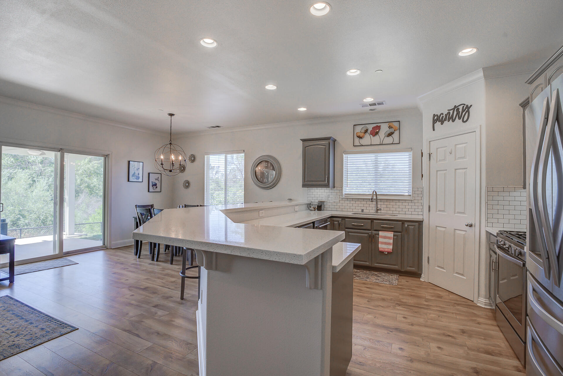 4090 Cambria Drive Redding, CA 96002 - Photo 12 of 48 a kitchen with stainless steel appliances granite countertop a stove top oven a sink dishwasher and a refrigerator with wooden floor