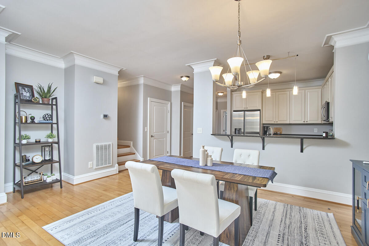 203 Valleyshire Road Durham, NC 27707 - Photo 18 of 37 a dining room with wooden floor and chandelier