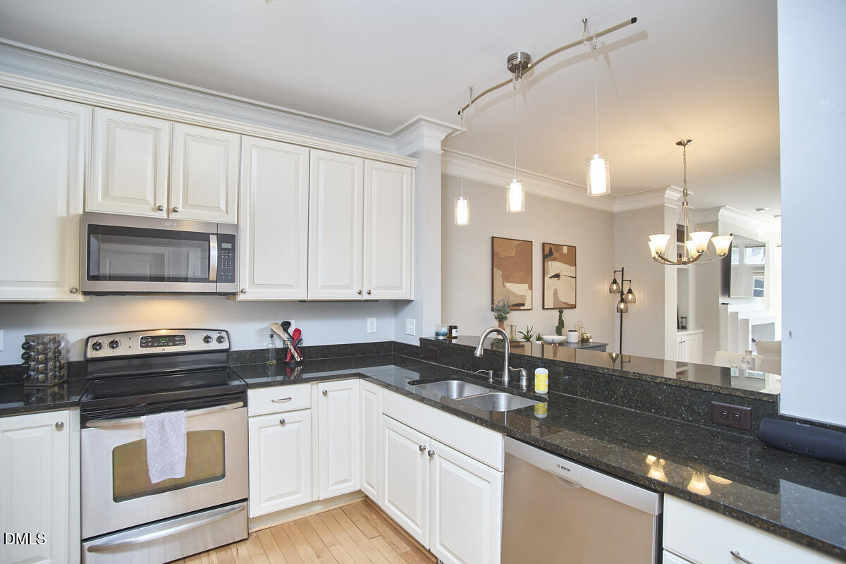 203 Valleyshire Road Durham, NC 27707 - Photo 19 of 37 a kitchen with granite countertop white cabinets and black stainless steel appliances