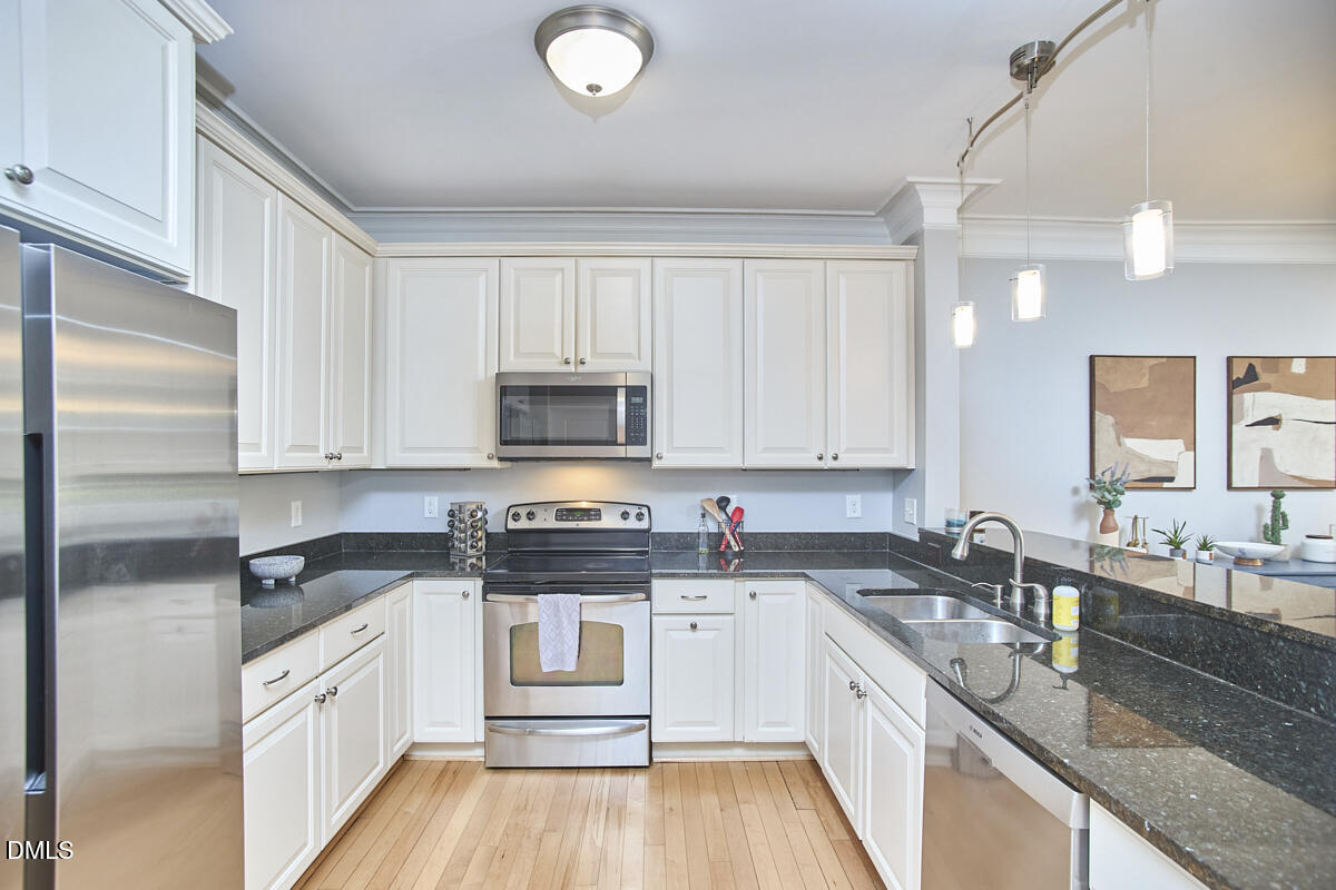 203 Valleyshire Road Durham, NC 27707 - Photo 20 of 37 a kitchen with stainless steel appliances a sink a stove a refrigerator cabinets and a window