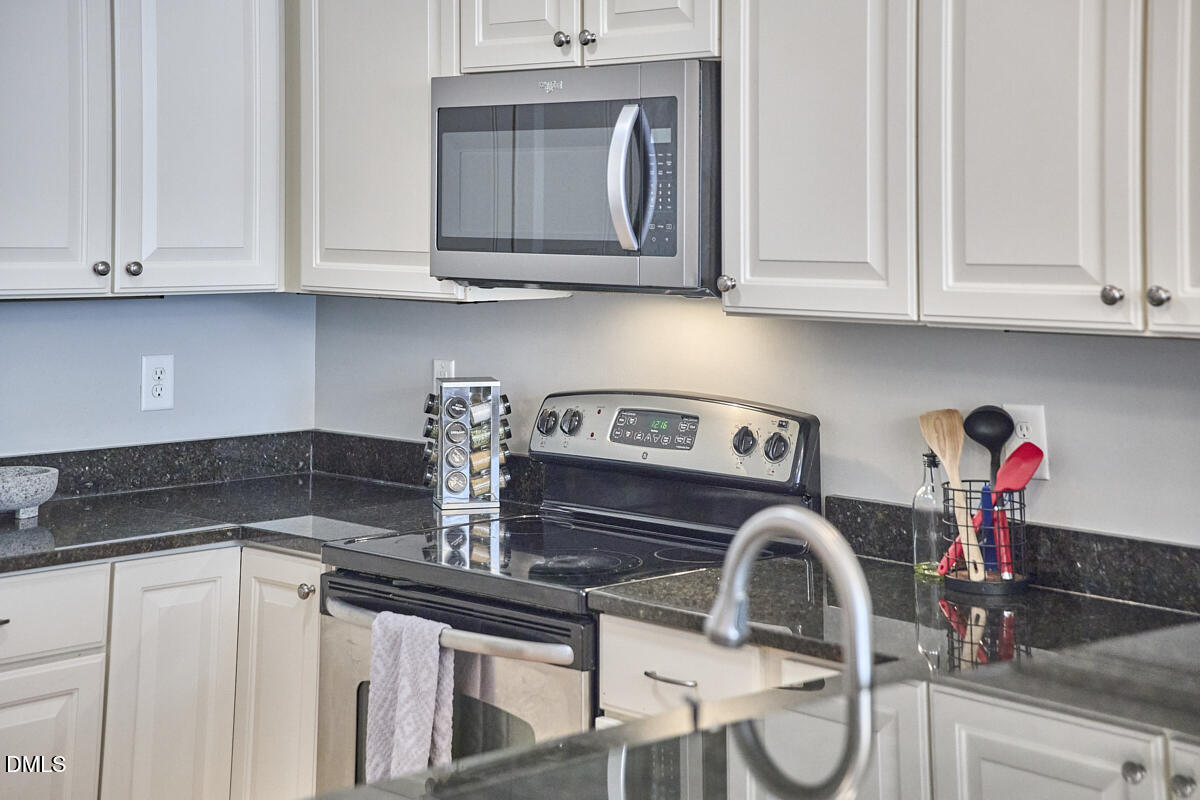 203 Valleyshire Road Durham, NC 27707 - Photo 21 of 37 a kitchen with stainless steel appliances granite countertop a sink a stove and cabinets