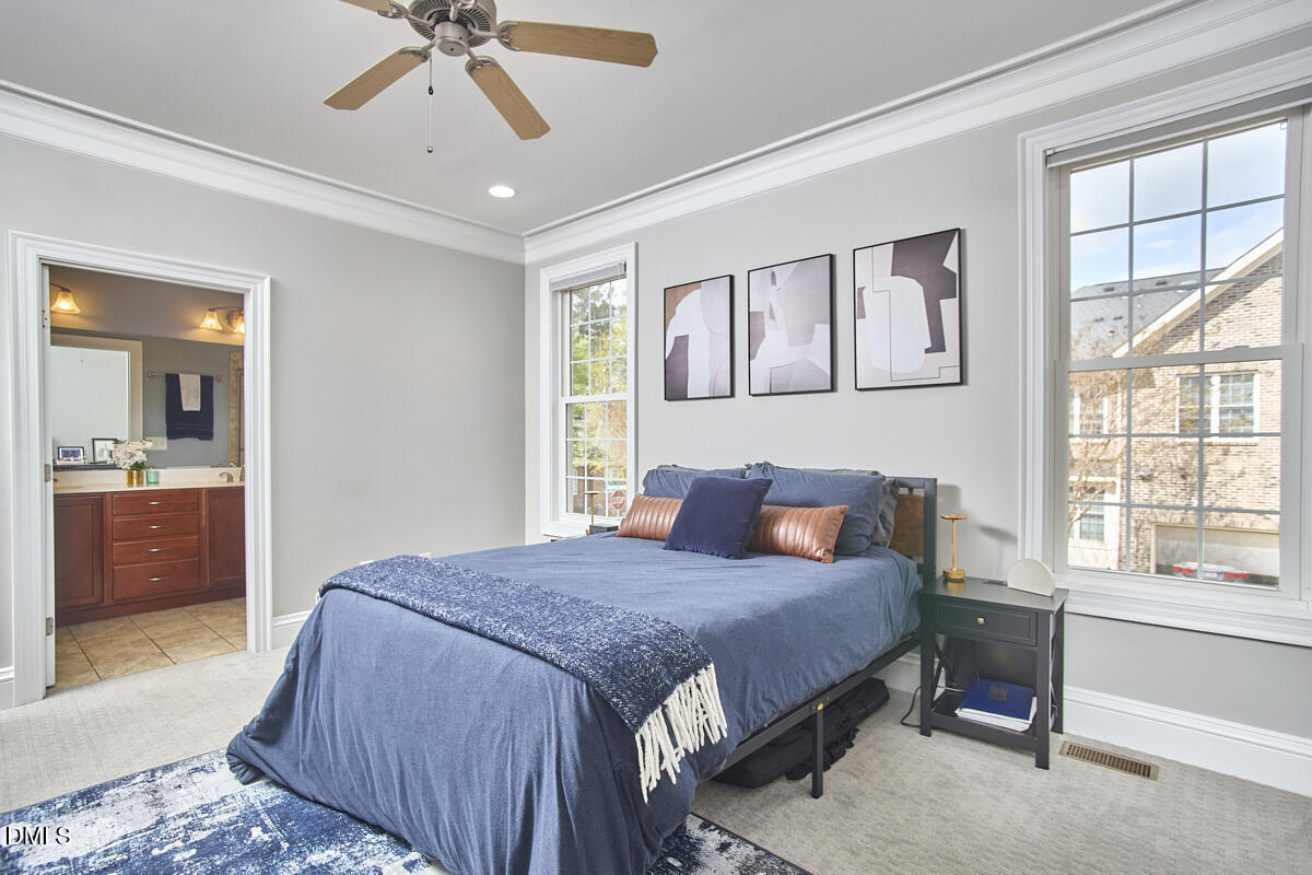203 Valleyshire Road Durham, NC 27707 - Photo 24 of 37 a bedroom with a large bed and a chandelier fan