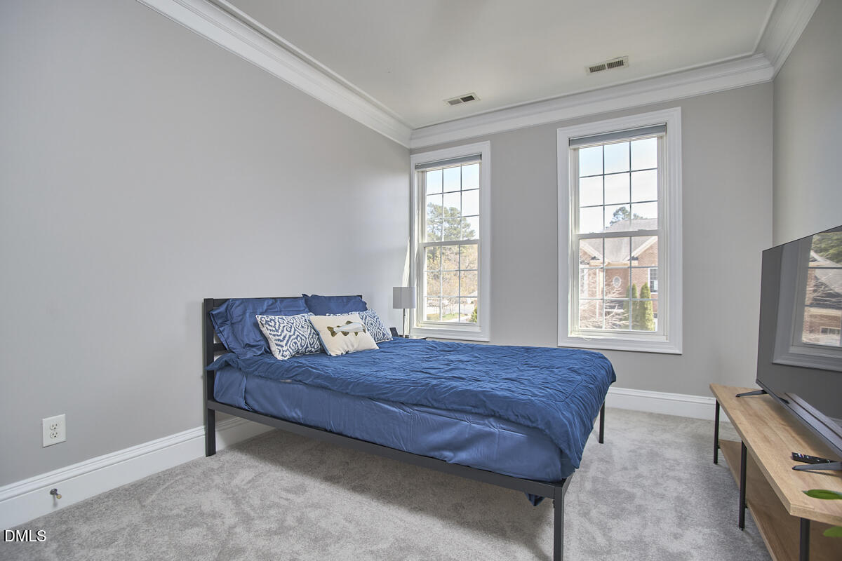 203 Valleyshire Road Durham, NC 27707 - Photo 28 of 37 a bedroom with a bed and a flat tv screen on a dresser