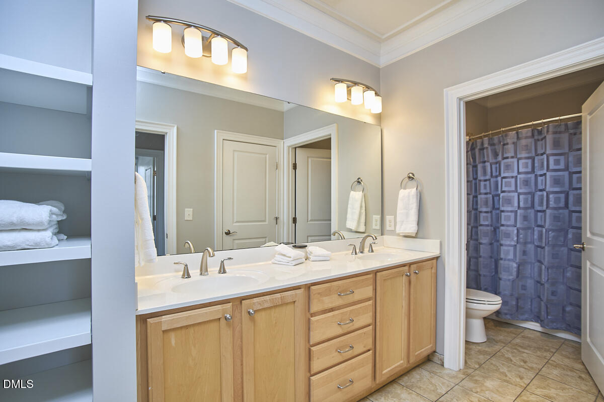 203 Valleyshire Road Durham, NC 27707 - Photo 29 of 37 a bathroom with a double vanity sink a toilet and a mirror