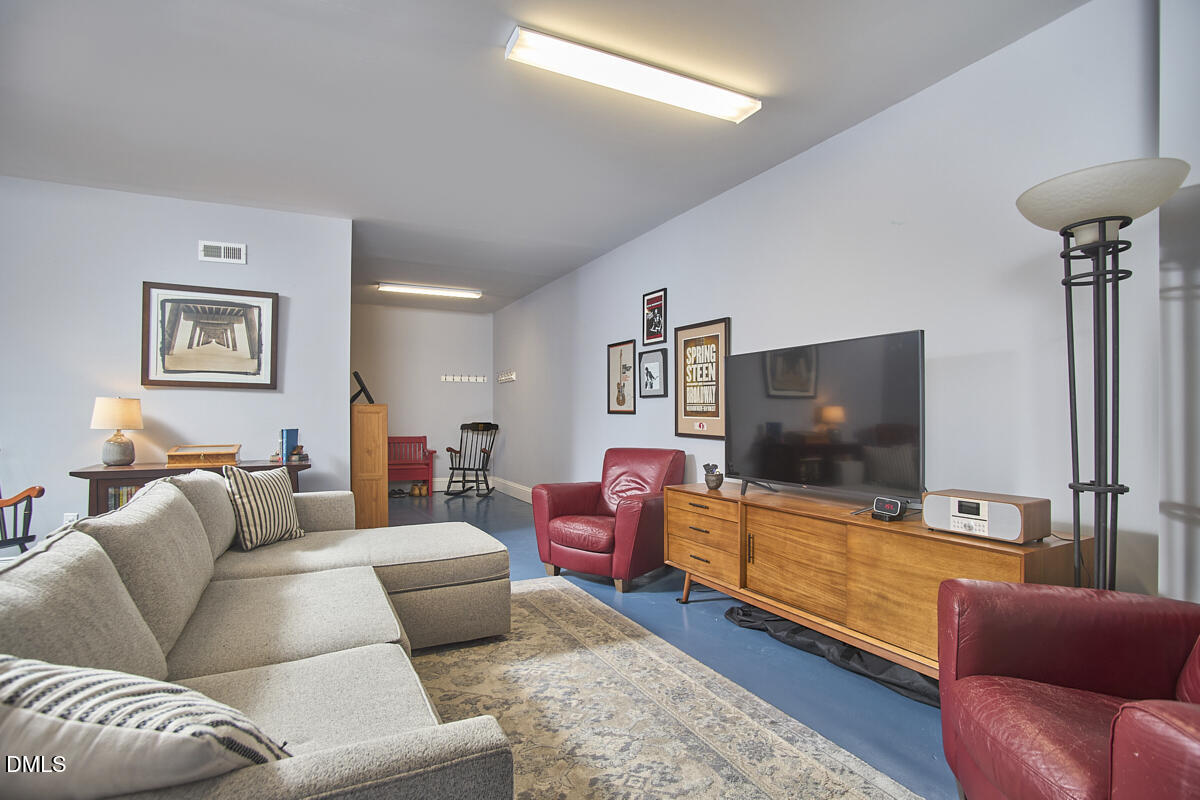 203 Valleyshire Road Durham, NC 27707 - Photo 32 of 37 a living room with furniture and a flat screen tv