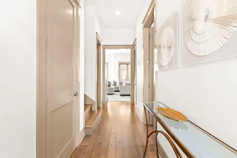 a view of a hallway with wooden floor and staircase