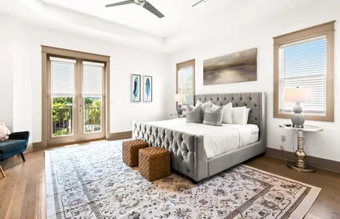a bedroom with a bed lamp on desk and a window