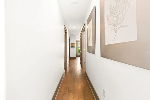 a view of a hallway with wooden floor