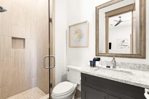 a bathroom with a granite countertop sink toilet and shower