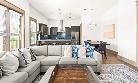 a living room with furniture wooden floor and a large window