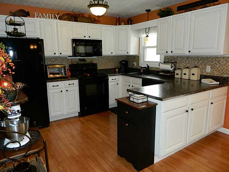 552 Country Club Road Washington, PA 15301 - Photo 9 of 25 Kitchen. The modern white kitchen with laminate floor has a tile backsplash and newer contrasting countertops. New black appliances added in 2011 are included.
