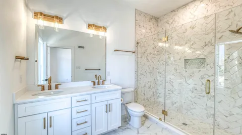 a bathroom with a sink a toilet and shower