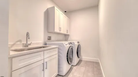a utility room with sink dryer and washer