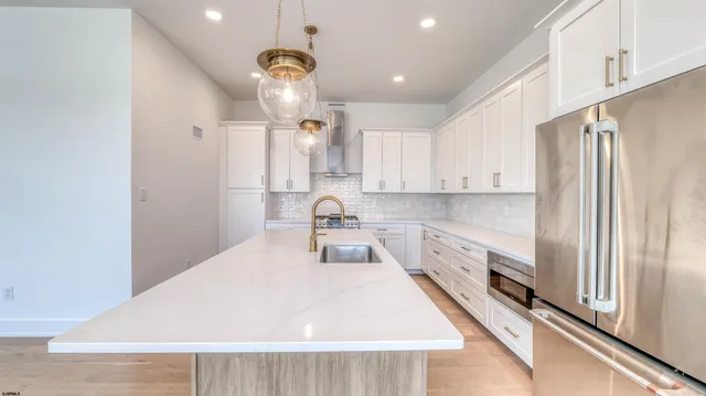 a kitchen with stainless steel appliances a refrigerator and a stove top oven