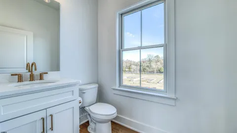 a bathroom with a sink toilet a mirror and window