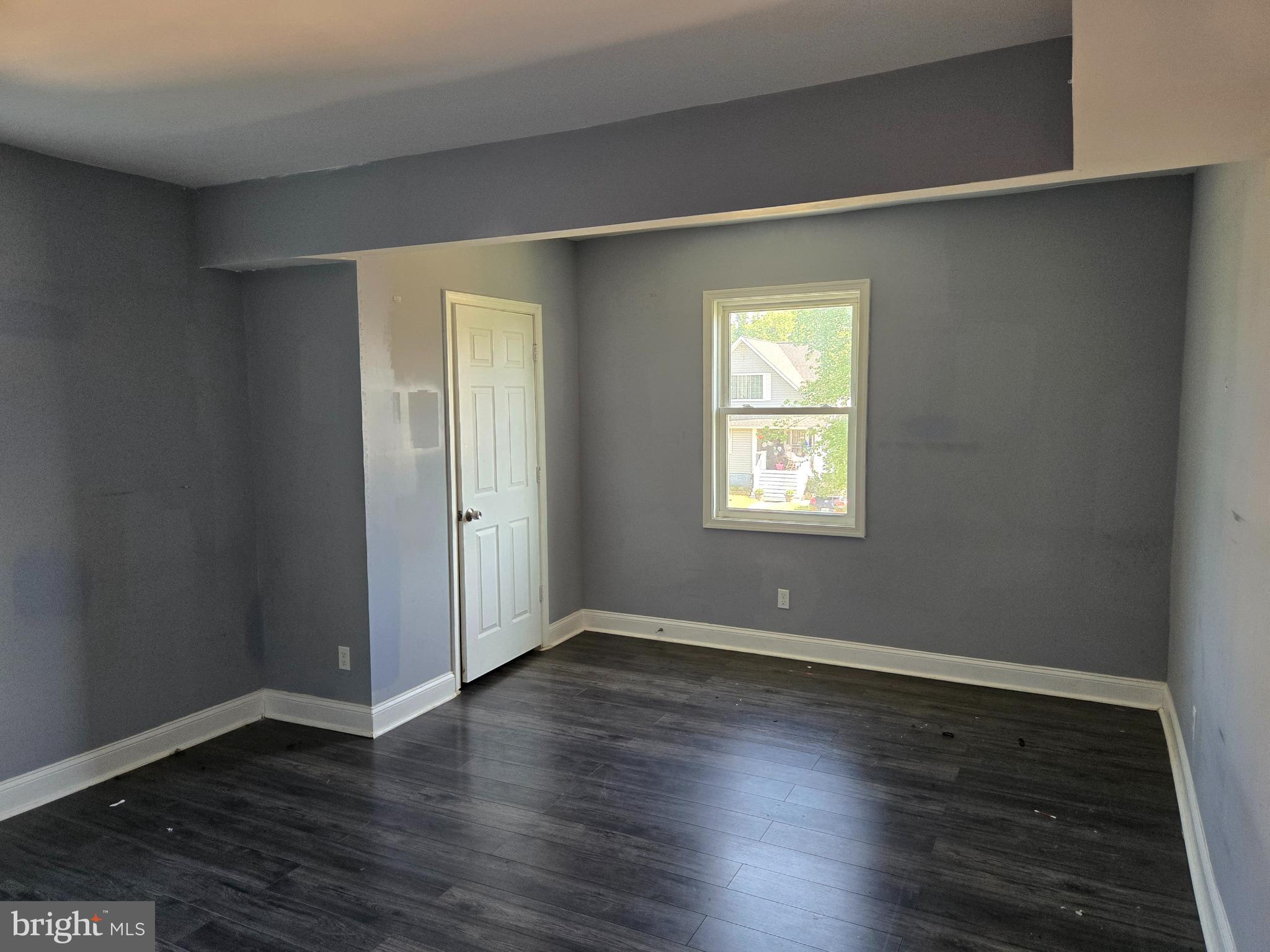 3811 Barrington Road Baltimore, MD 21215 - Photo 45 of 50 a view of an empty room with wooden floor and a window