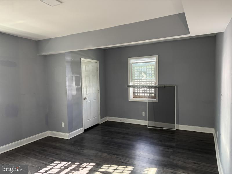 3811 Barrington Road Baltimore, MD 21215 - Photo 8 of 50 an empty room with wooden floor and windows