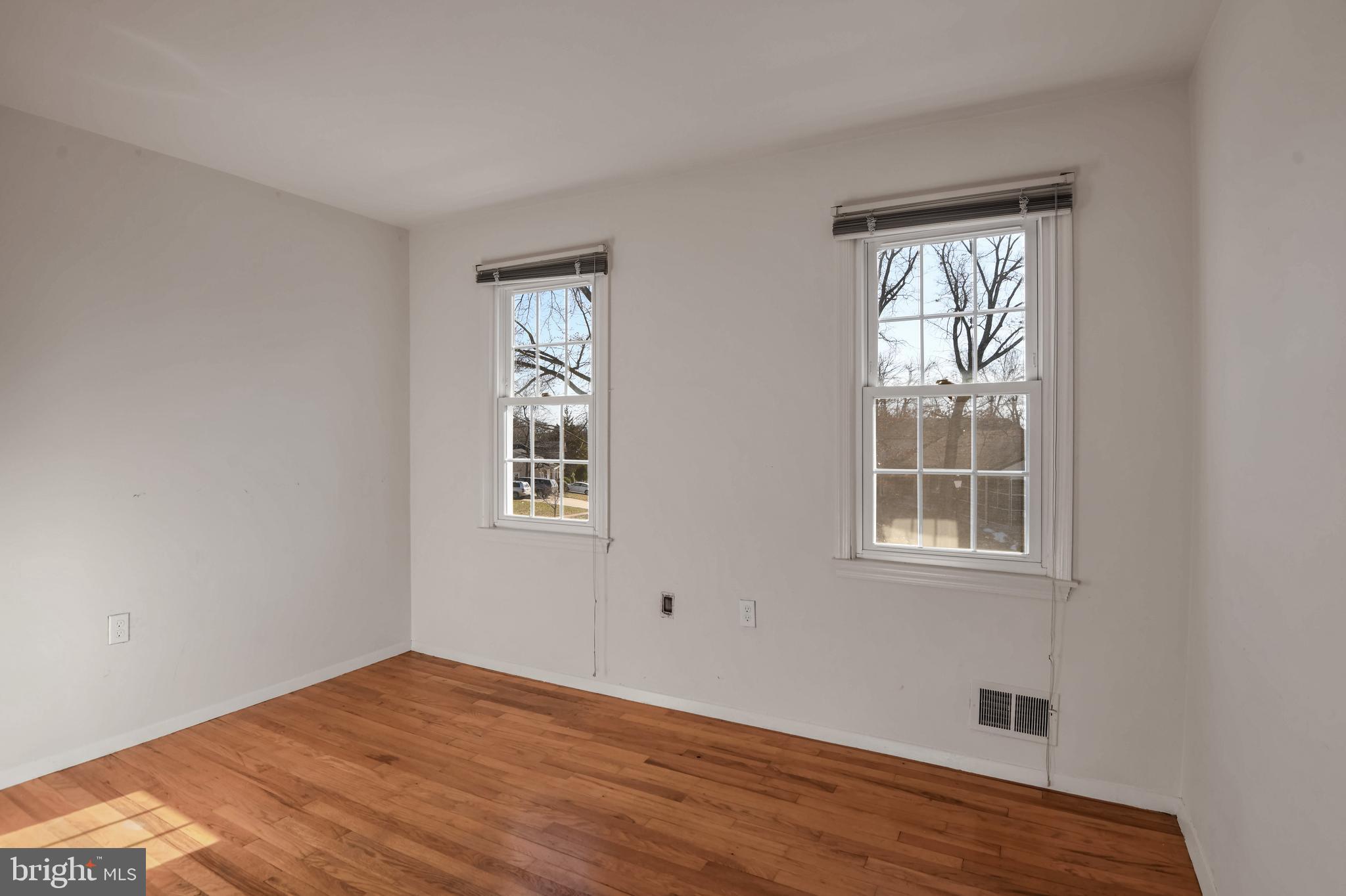 8310 Nightingale Drive Greenbelt, MD 20770 - Photo 13 of 27 a view of an empty room with wooden floor and a window