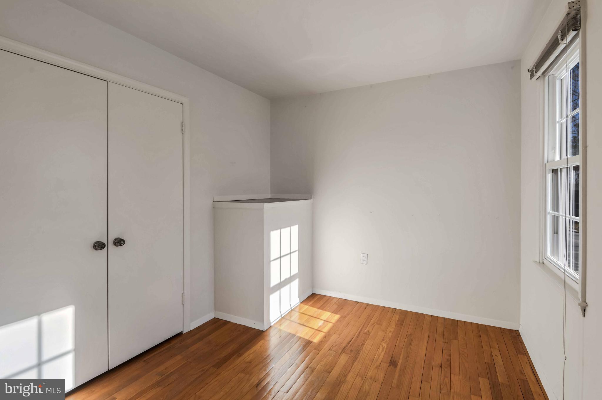8310 Nightingale Drive Greenbelt, MD 20770 - Photo 14 of 27 an empty room with wooden floor and windows