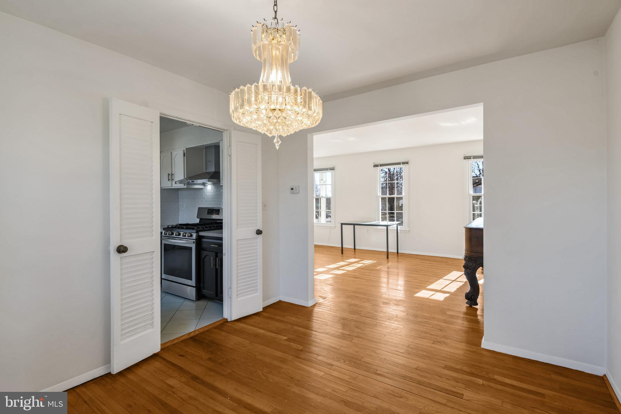 8310 Nightingale Drive Greenbelt, MD 20770 - Photo 7 of 27 a view of a room with wooden floor chandelier and entryway
