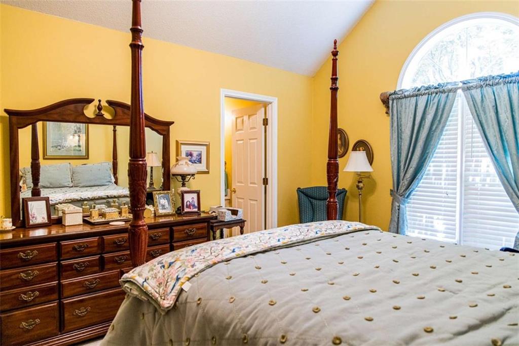106 Eden Drive Northwest Rome, GA 30165 - Photo 13 of 23 a bedroom with a large bed and a chandelier