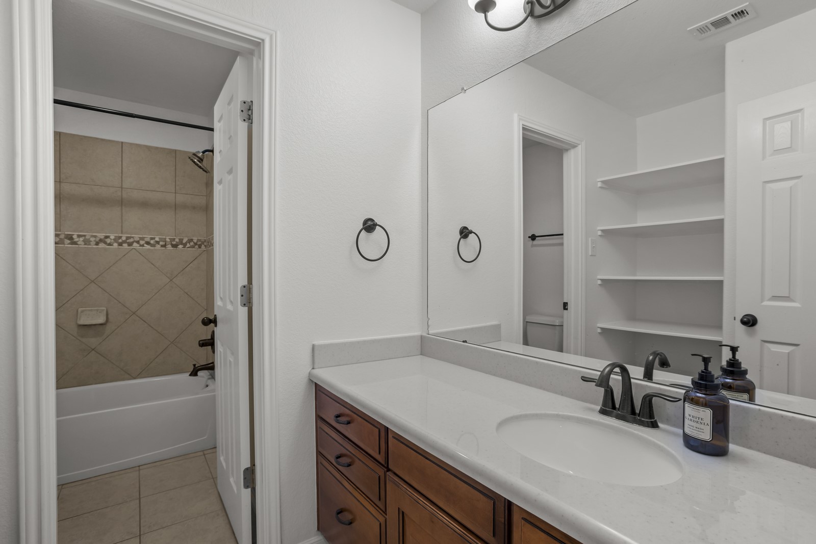 245 Razzmatazz Trail Buda, TX 78610 - Photo 29 of 37 Bathroom vanity featuring a light-colored countertop, integrated sink, and wood-finish cabinetry