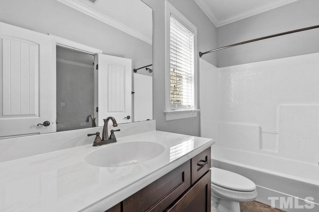 2325 Finley Ridge Lane Raleigh, NC 27615 - Photo 23 of 30 a bathroom with a granite countertop sink a toilet and shower