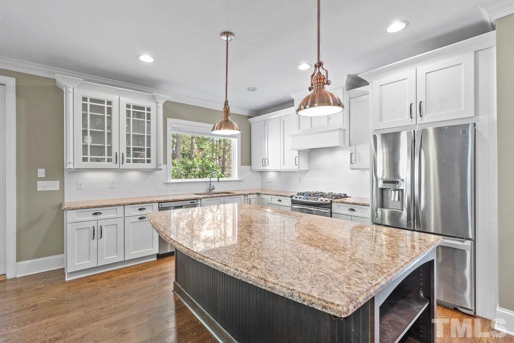 2325 Finley Ridge Lane Raleigh, NC 27615 - Photo 7 of 30 a kitchen with kitchen island granite countertop a stove a sink a center island and wooden floor
