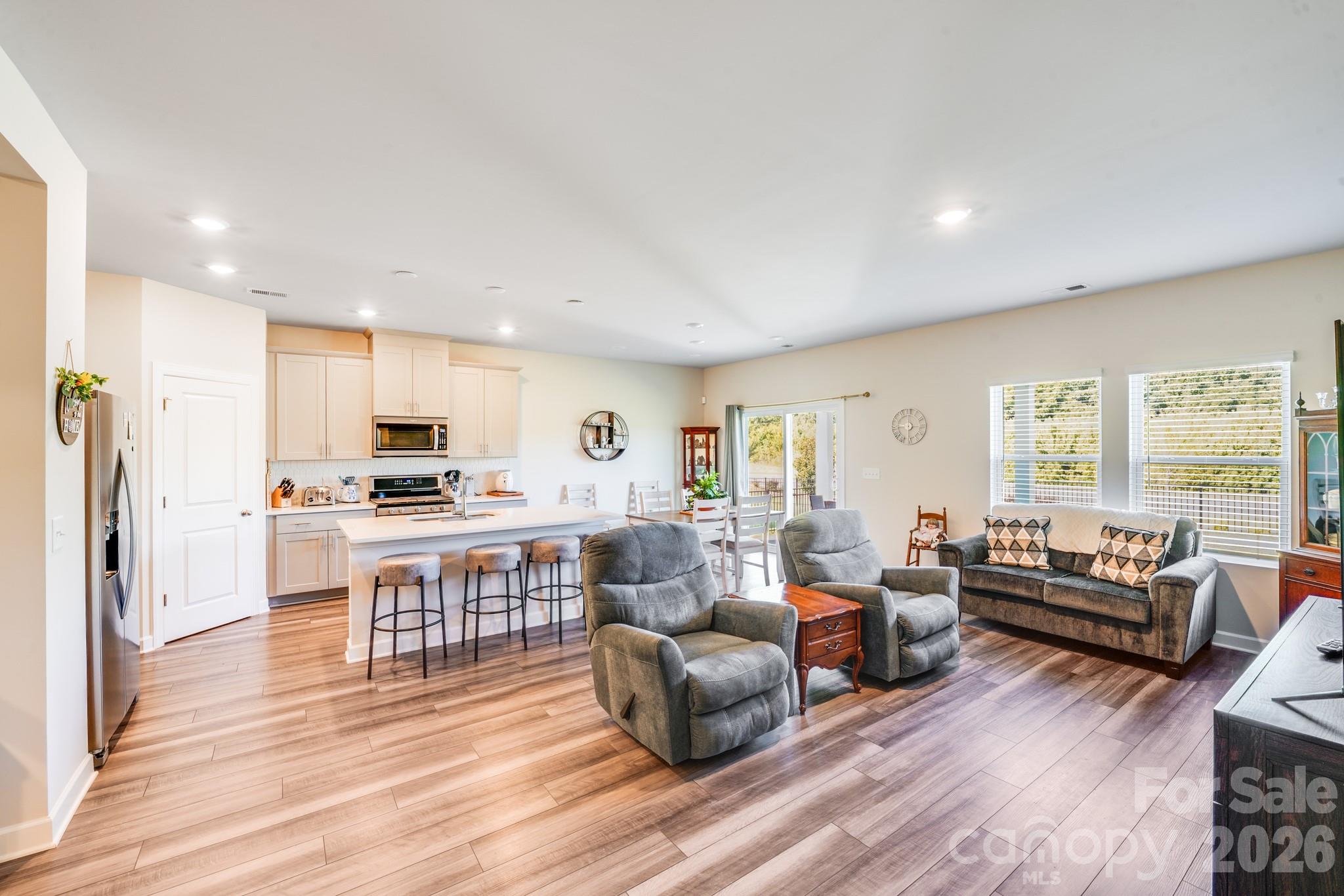 1340 Sweet Pea Street Monroe, NC 28110 - Photo 12 of 32 a living room with furniture a wooden floor and a large window