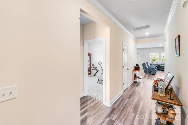 a view of a hallway with wooden floor and a living room