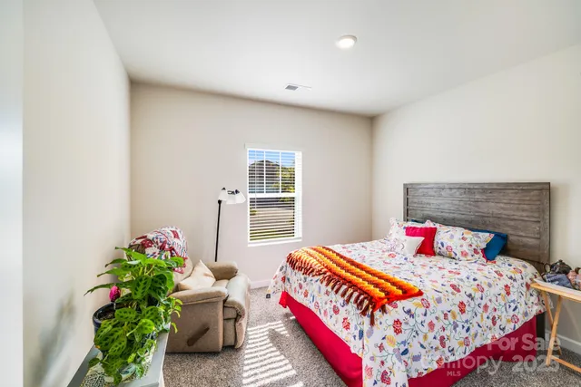 a bedroom with bed and a potted plant