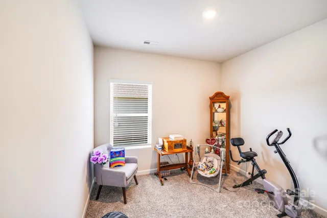 a living room with furniture a window and gym equipment