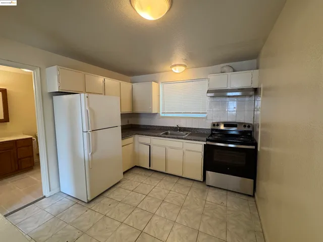 a kitchen with a refrigerator and a stove