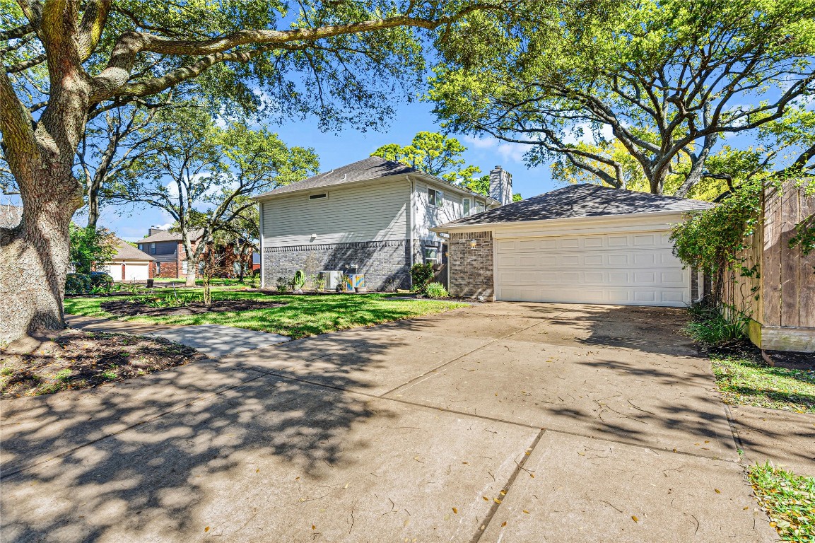 7906 Duncansby Vale Road Houston, TX 77095 - Photo 6 of 48 View of the side of the home, the 2-car garaged and the double-wide driveway. The large, mature trees offer convenient shade, energy savings, and they are just a lovely sight.