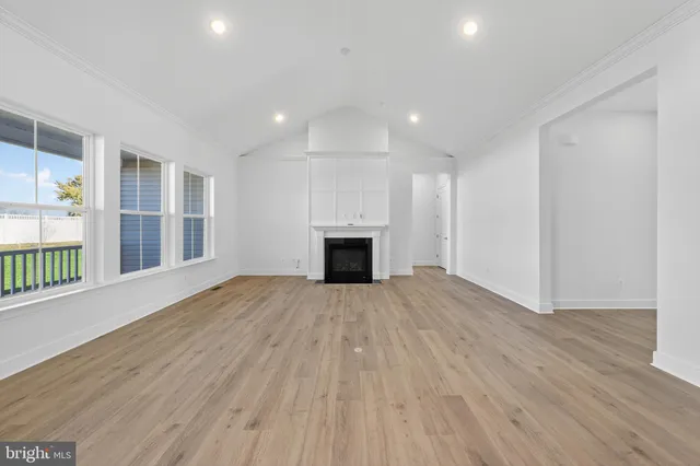 an empty room with wooden floor and fireplace