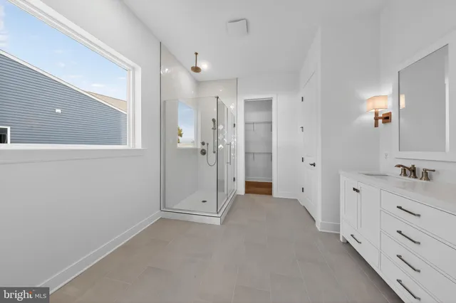 a spacious bathroom with a shower a sink and mirror
