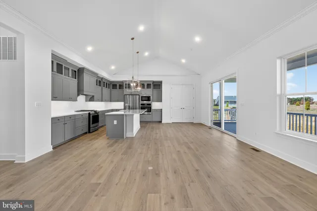 a large kitchen with stainless steel appliances granite countertop a large center island a sink a stove and a refrigerator