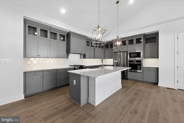 a large kitchen with stainless steel appliances granite countertop a stove and a sink