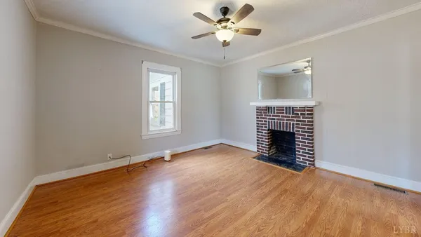 a view of an empty room with a fireplace and a window