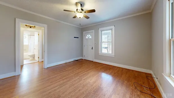 an empty room with wooden floor and windows