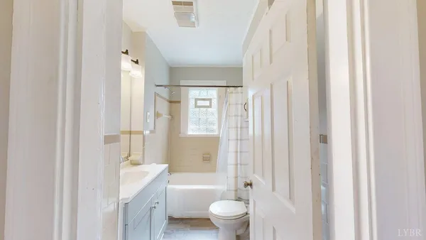 a bathroom with a granite countertop sink a toilet and shower