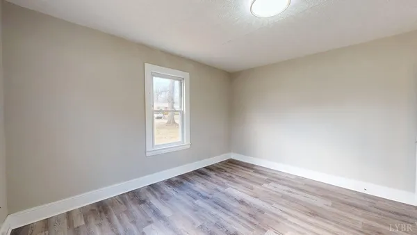 wooden floor in an empty room with a window
